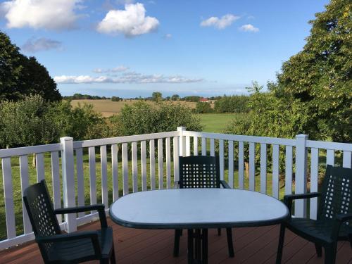 einen blauen Tisch und Stühle auf einer Terrasse mit Meerblick in der Unterkunft Ferienhaus in Zimmert mit Terrasse, Grill und Garten in Rieseby