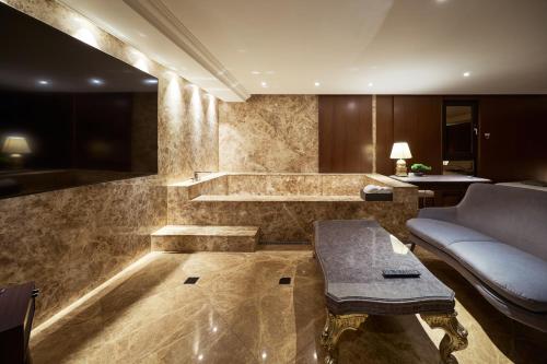 a living room with a couch and a table at 컬리넌 호텔 앤 스파 in Seoul