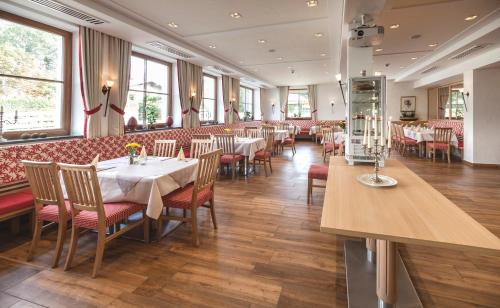 ein Esszimmer mit Tischen und Stühlen in einem Restaurant in der Unterkunft Gasthof - Hotel Zur Post in Neukirchen am Teisenberg