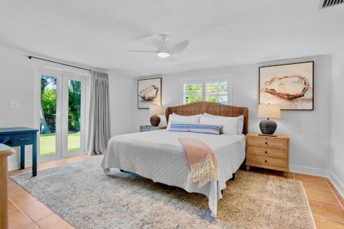 a bedroom with a bed and a dresser and windows at Lavender Lagoon in Anna Maria