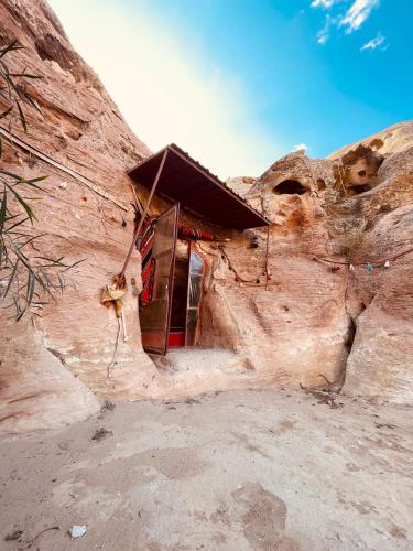 a small building in a rock formation in the desert at Little Petra Bedouin Camp in Al Ḩayy