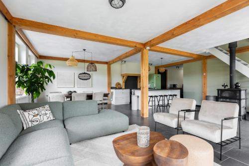 a living room with a couch and a table at Villa Crème de la Kremmer with Hottub & Sauna | 8 persons in Gasselte