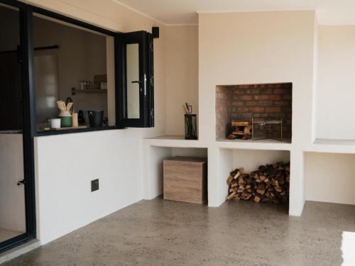 a fireplace in a living room with a pile of fire wood at Bergendam Eco Lodge in Venterstad