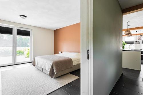 a bedroom with a bed and a kitchen at Villa Crème de la Kremmer met Hottub & Sauna | 8 personen in Gasselte