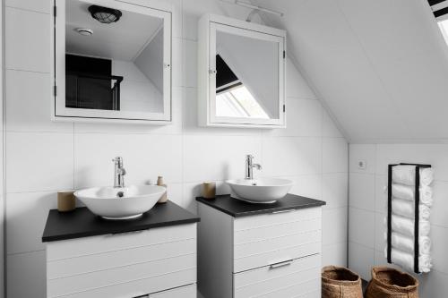 a bathroom with two sinks and two mirrors at Villa Crème de la Kremmer met Hottub & Sauna | 8 personen in Gasselte