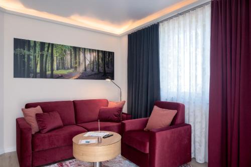 萨斯尼茨Villa Nause-FeWo Buchenfreund mit Spa und Freizeit的客厅里有一张红色的沙发和一张桌子