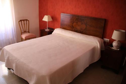 a bedroom with a large white bed and a chair at Maison Puigpelat in Puigpelat