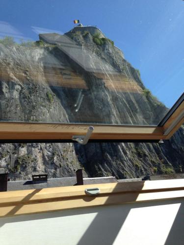 a view of a mountain through a window at Les Voisins De Mr Sax in Dinant