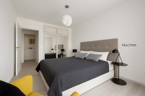 a bedroom with a large bed and a yellow chair at Fairytale in Adeje in Adeje