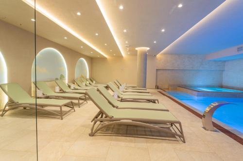 a waiting room with a row of chairs and a swimming pool at Hotel HOGO in Inđija