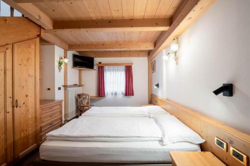 ein Schlafzimmer mit zwei Betten in einem Zimmer in der Unterkunft EL CIASEL in Canazei