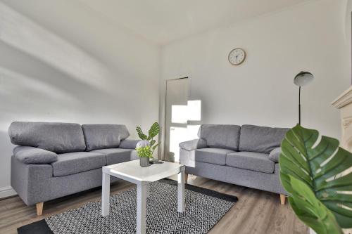 a living room with two couches and a table at Athol House, near Old Trafford, Free Parking in Manchester