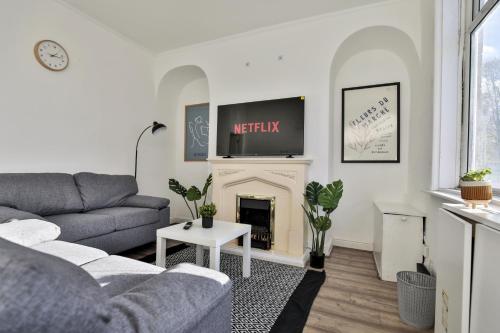 a living room with a couch and a fireplace at Athol House, near Old Trafford, Free Parking in Manchester