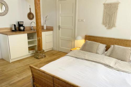 een slaapkamer met een bed en een keuken met een tafel bij Texel Atelier in De Koog