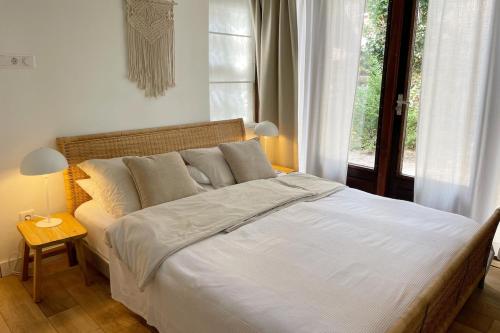 een slaapkamer met een groot wit bed en een raam bij Texel Atelier in De Koog