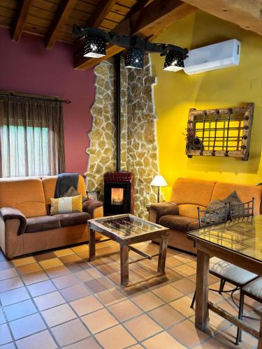 a living room with couches and a fire place at Casa Rural El Regajo in Tenzuela
