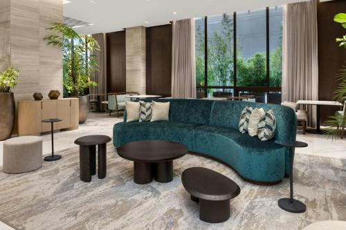 Una sala de estar con un sofá azul y mesas. en The Westin Panama, en Panamá