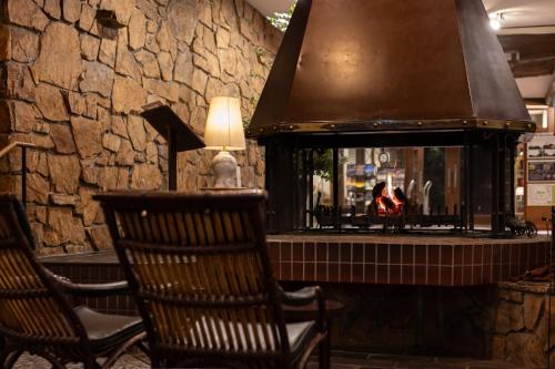 a lobby with two chairs and a fireplace at Yatsugatake Kogen Lodge in Minamimaki