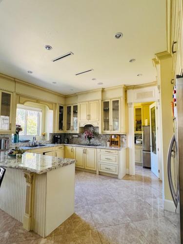 a large kitchen with white cabinets and a counter top at Grace Sweet Homes Kingsize Bedroom NOT A PRIVATE HOUSE - SHARED AMENITIES in Richmond