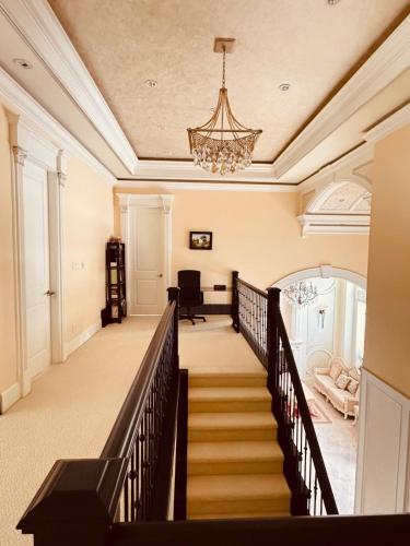 a staircase in a home with a chandelier at Grace Sweet Homes Kingsize Bedroom NOT A PRIVATE HOUSE - SHARED AMENITIES in Richmond