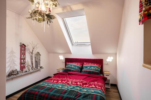 a bedroom with a red bed and a skylight at Domki u Duszy in Brenna