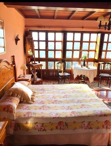 a bedroom with a large bed and a table at La Quintana del Sol in Aramil de Arriba