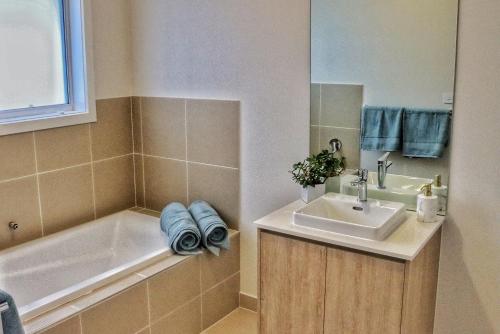 a bathroom with a sink and a bath tub and a sink at Seafoam, Cowes, New Home, Fast NBN WIFI in Cowes