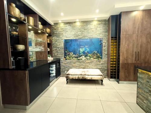 Una sala de estar con un acuario y una otomana. en 40 On Jacopever, en Richards Bay