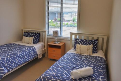 a bedroom with two beds and a window at Seafoam, Cowes, New Home, Fast NBN WIFI in Cowes