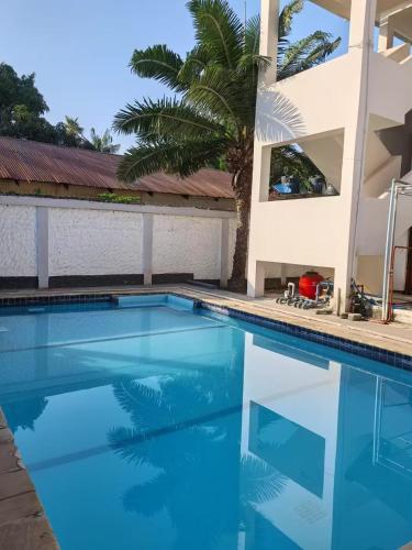 a swimming pool with blue water in front of a building at Huasheng Hotel in Dar es Salaam