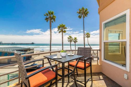 een tafel en stoelen op een balkon met uitzicht op het strand bij 5N-64 Beachfront On the Strand in Oceanside