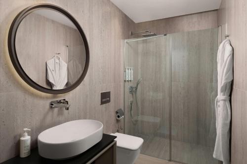 a bathroom with a shower and a sink and a mirror at Marriott Executive Apartments Antalya in Antalya