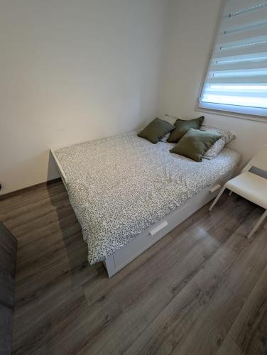 a bed in a white room with a window at City Break Arras in Arras