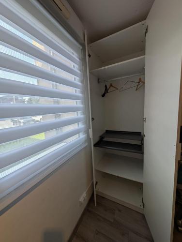 a walk in closet with blinds on the window at City Break Arras in Arras