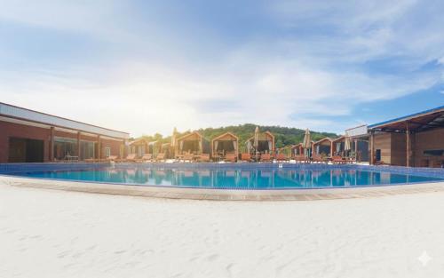a large swimming pool with chairs and a building at Royal C Resort in Sihanoukville