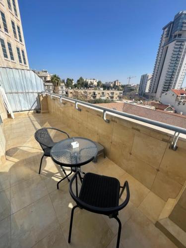 un patio con tavolo e sedie sul tetto di Bright Mahane Yehuda 1 BR with Private Terrace a Gerusalemme