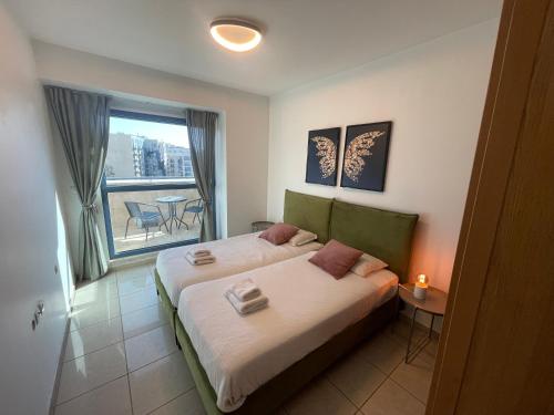 una camera da letto con un letto e vista su un balcone di Bright Mahane Yehuda 1 BR with Private Terrace a Gerusalemme