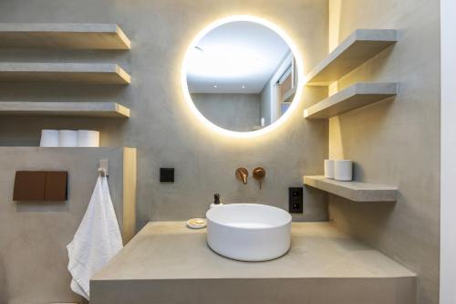 a bathroom with a round sink and a mirror at Cala Nostra Bea in Palafrugell