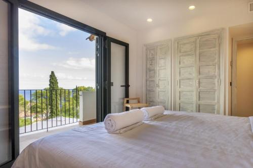 a bedroom with a bed and a large window at Cala Nostra Bea in Palafrugell