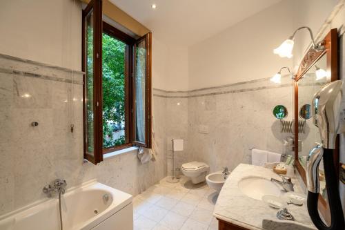 une salle de bain avec une baignoire, un lavabo et des toilettes dans l'établissement Relais Le Felci Executive Suite Spa, à Fiuggi