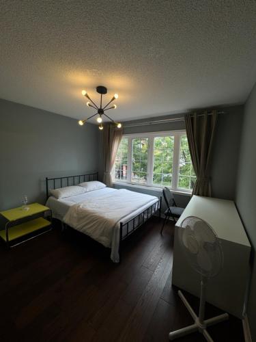 多伦多Gorgeous Private room的一间卧室设有一张床、一个窗口和风扇