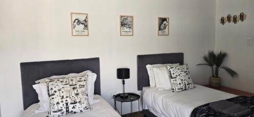 米德尔堡Middelburg Guesthouse的卧室配有两张床,墙上挂着植物