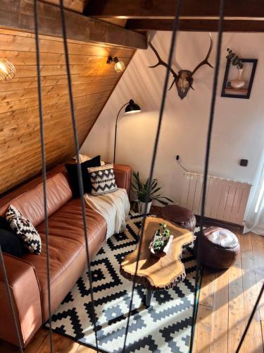 ein Wohnzimmer mit Sofa und Tisch in der Unterkunft Chalet A Baisoara - Piscină încălzită - Pârtii în apropiere in Băişoara