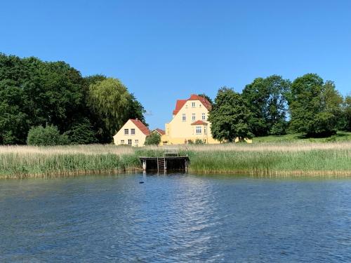 a house on the side of a river with a house at Wohnung Im Zweiten Obergeschoss Des Gutshauses in Neuenkirchen