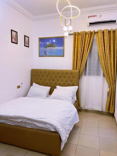 a bedroom with a bed and a chandelier at B&L Apartments in Port Harcourt