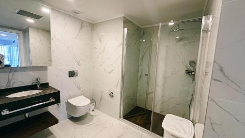 ein Badezimmer mit Dusche, Toilette und Waschbecken in der Unterkunft Grand Sapphire Hotel, Casino & Holiday Deluxe Residential Home in Iskele