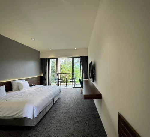 a bedroom with a bed and a desk and a window at Mountain Hill in Mai Sơn