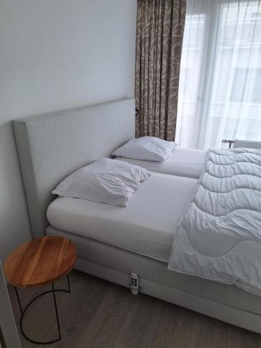 a bedroom with a bed with a table and a window at Residentie Isis in Blankenberge