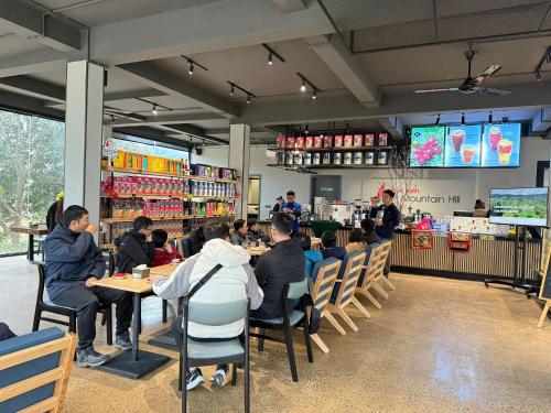 um grupo de pessoas sentadas às mesas de um restaurante em Mountain Hill em Mai Sơn