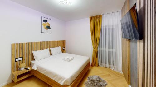 ein Schlafzimmer mit einem Bett und einem Fernseher darin in der Unterkunft Regina Urban Stay VRT in Şelimbăr